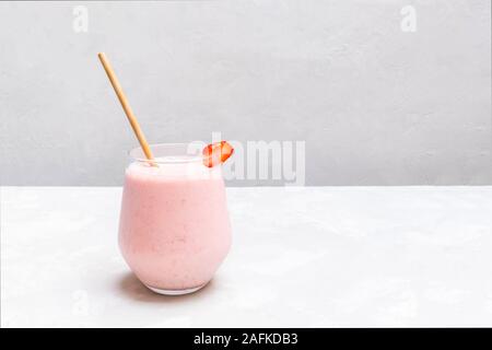Cup of Indian drink Strawberry Lassi on neutral concrete background Stock Photo