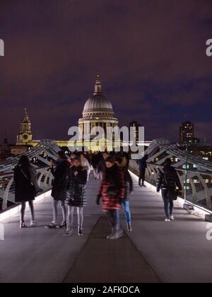 Tourists Crossing Millennium Bridge, River Thames, with St Pauls Cathedral, Night Time London Landscape, England, UK, GB.