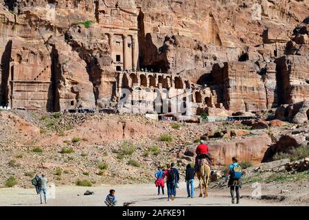 Petra, Jordan - March 06, 2019: Unidentified people at UNESCO World heritage site of ancient Petra with royal tombs in background