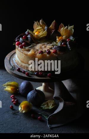 Cheesecake with figs and physalis on a holder vertical Stock Photo