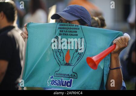 San Salvador, El Salvador. 16th Dec, 2019. A man covers his face with a union flag. Workers from the public health sector protested outside of the Ministry of Treasury against budget cuts and mass layoffs performed by Salvadoran President Nayib Bukele. Credit: Camilo Freedman/ZUMA Wire/Alamy Live News Stock Photo