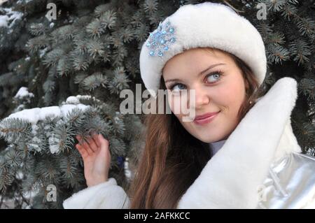 Cherkasy, Ukraine,December,24, 2011: young attractive woman dressed as Snow Maiden posing to photographers near the  Christmas tree Stock Photo