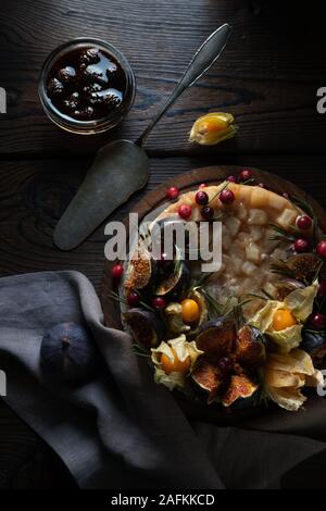 Cheesecake with dates and physalis on a stand with a napkin top view