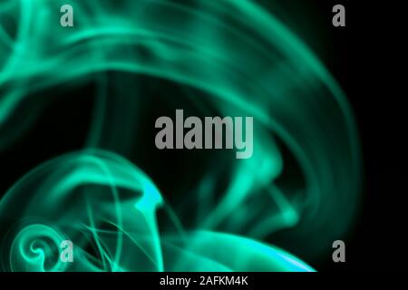 abstract background with blurred green smoke on black, smoky abstract background Stock Photo
