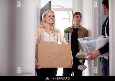 Group Of College Student Carrying Boxes Moving Into Accommodation Together Stock Photo