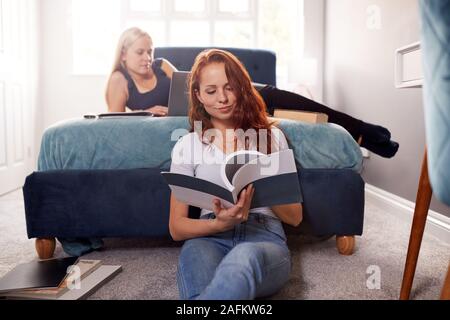Two Female College Students In Shared House Bedroom Studying Together Stock Photo