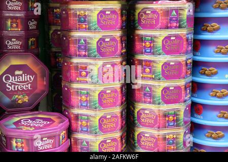1KG giant tin of Quality Street stacked in supermarket shelf, Christmas 2019 Stock Photo