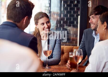 Group Of Business Colleagues Meeting For Drinks And Socializing In Bar After Work Stock Photo