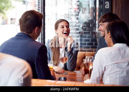 Group Of Business Colleagues Meeting For Drinks And Socializing In Bar After Work Stock Photo