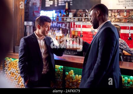 Two Businessmen Making A Toast As They Meet For Drinks And Socialize In Bar After Work Stock Photo