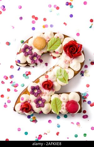 Number two cake decorated with flowers, macarons and confetti isolated on white background. Copy space Stock Photo