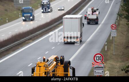 Rangsdorf, Germany. 16th Dec, 2019. A worker on the A13 motorway removes the cross from the traffic sign to the speed limit. A speed limit of 130 kilometres per hour now applies on a section of the A13 motorway. Between the Schönefeld junction and the Spreewald triangle, a total of 178 speed-limiting traffic signs were installed in both directions. According to the State Road Service, the section has a length of about 60 kilometres. Credit: Soeren Stache/dpa-Zentralbild/dpa/Alamy Live News Stock Photo