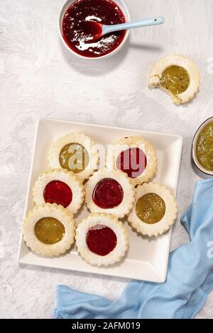 Top view of colorful linzer cookies in round shape on light background. Vertical shot Stock Photo