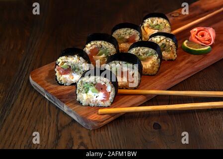 hot roll set sashimi japanese food on wooden background with lemon and chopsticks