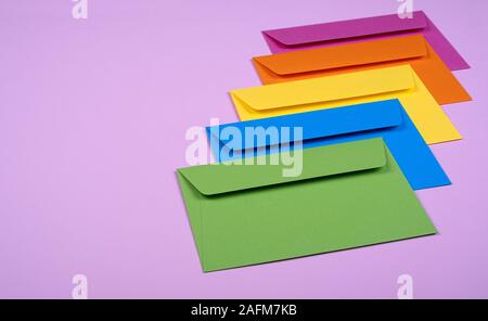 tidy coloured envelopes on a light pink background Stock Photo