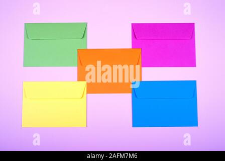 tidy coloured envelopes on a light pink background Stock Photo