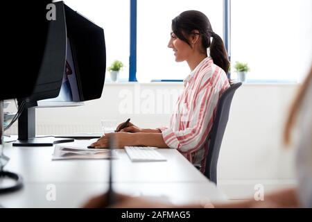 Female Retoucher Working At Computer Using Graphics Tablet In Post Production Company Stock Photo