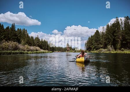Woman paddles on the Deschutes River in a pack raft in Oregon. Stock Photo