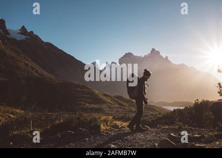 Backpacker walking in mountains in sunny day Stock Photo