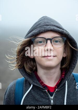 Portrait of tween wearing glasses and hood smiling Stock Photo
