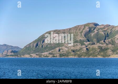 fjord landscape with steep slopes of island on fjord waters, shot under bright summer light at Leka island,  Norway Stock Photo