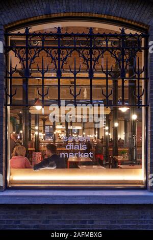 Window view into Seven Dials Market. Seven Dials Market, London, United Kingdom. Architect: Stiff + Trevillion Architects, 2019. Stock Photo