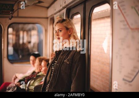 Young thoughtful woman traveling in subway train Stock Photo