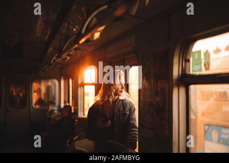 Young woman looking through window traveling in subway train Stock Photo