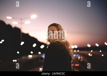 Portrait of young confident woman standing on bridge against sky Stock Photo