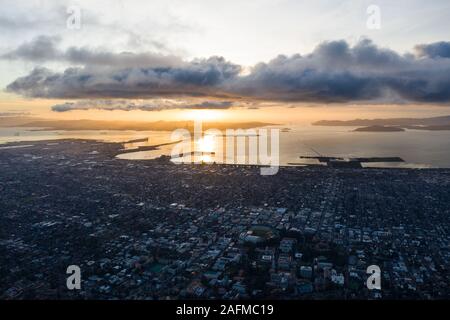 A serene sunset illuminates the densely populated San Francisco Bay area including Oakland, Berkeley, Emeryville, El Cerrito, and San Francisco. Stock Photo