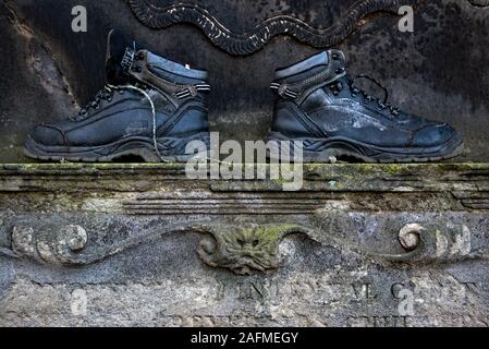 Pair of boots left on a monument in Greyfriars Kirkyard in Edinburgh, Scotland, UK. Stock Photo