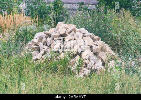 A pile of gray stones in the green grass Stock Photo