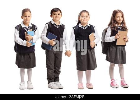 Full length portrait of three schoolgirls and one schoolboy wearing school uniforms isolated on white background Stock Photo