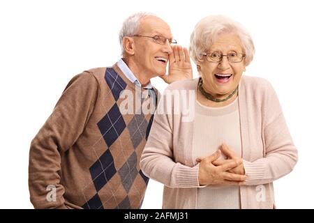 Senior man whispering to a senior woman isolated on white background Stock Photo