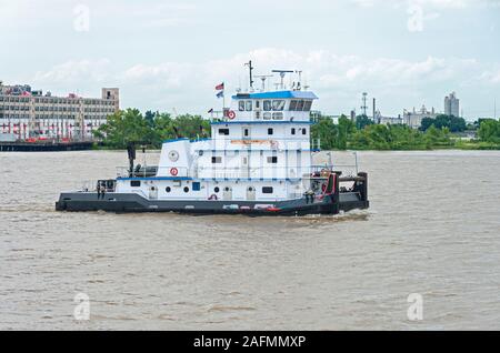 New Orleans, LA/USA – June 14, 2019: Towboat navigates Mississippi River through industrial section. Stock Photo