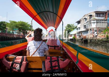 Tourists on Long-tail boat in canal, Bangkok, Thailand