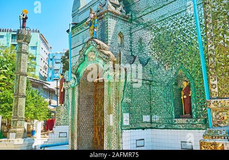 YANGON, MYANMAR - FEBRUARY 17, 2018: The entrance to Sein Yaung Chi Pagoda is decorated with carved details, fine mirror patterns and sculptures of Na Stock Photo