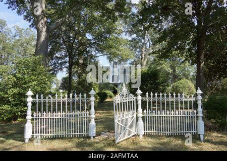 White gate in front of a beautiful white historic antebellem house Stock Photo