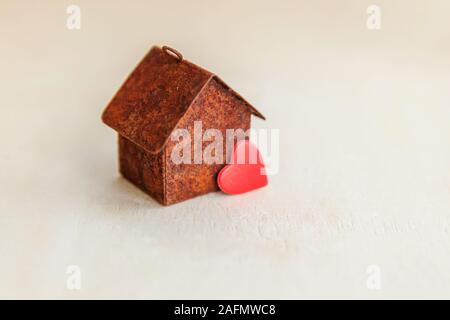 Miniature toy model house with red heart on wooden backdrop. Eco Village, abstract environmental background. Real estate mortgage property insurance sweet dream home ecology concept Stock Photo