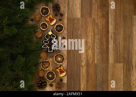 Christmas card with Christmas fir tree and ginger bread on rustic wooden background. Stock Photo