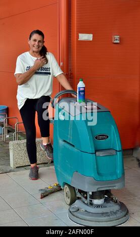 Woman with commercial floor polishing machine Stock Photo