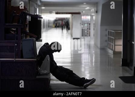 Homeless man sleeping in subway station, Philadelphia, USA Stock Photo