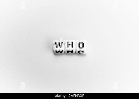 White cubes with question WHO on white paper background and dark shadows Stock Photo