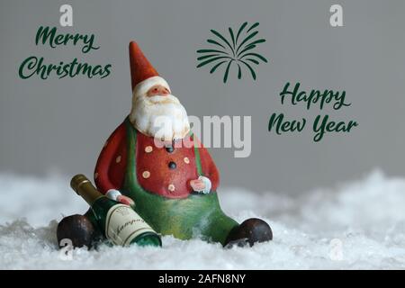 Snowman with a placard in his hand. Dressed with red scarf and gloves and hat in the snow outside announcing christmas under the snow. Front view Stock Photo