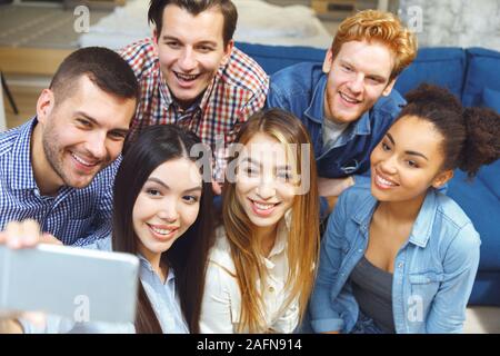 Group of friends having party indoors fun together taking selfie pictures close-up Stock Photo