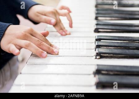 Children's hands on the keys of the piano. Piano lessons for kids. Stock Photo