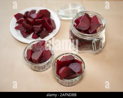 Cooked red slices beetroot in plate on wooden background. Stock Photo