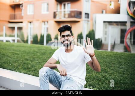 Young indian man greeting with hands someone in the street Stock Photo