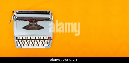 Old vintage style typewriter top view photo on yellow background Stock Photo