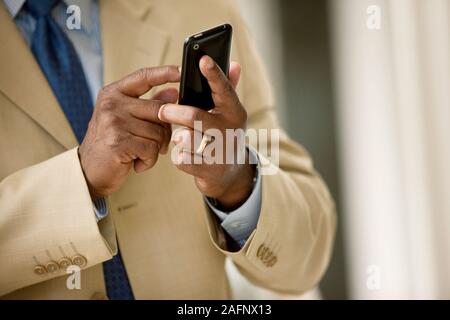 Mid-adult businessman texting on his cell phone. Stock Photo